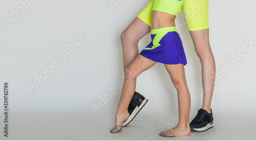 Two ballerinas, gzmnasts child girl and woman. Little kid and adult teacher are studying choreographic position for legs in white classical dance school. Practicing for children. Close up. photo