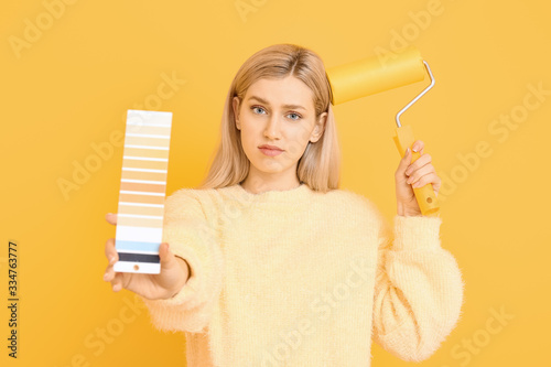 Young woman holding paint r...