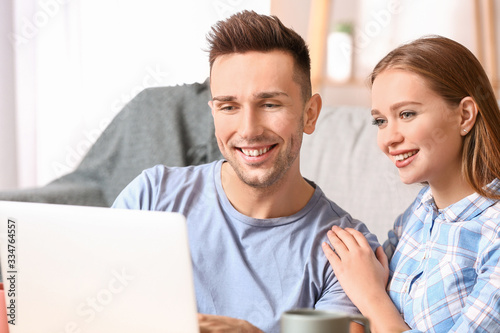 Happy young couple using la...
