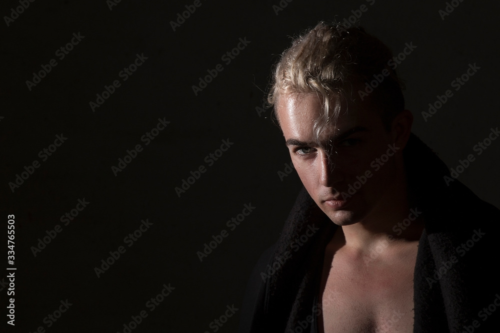  Sexy blond man on a black background. Beautiful, elegant, advertising, brutal, glamor, model, profile, pose