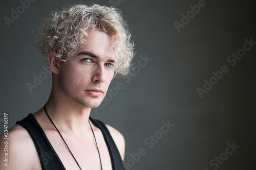  Portrait of a man on a gray background. Young blond man, northern type of man, style, fashion, vogue, model, emotions