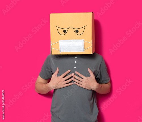 Man wearing cardboard box with mask to protect from COVID 19 virus,Man with different diseases symptoms