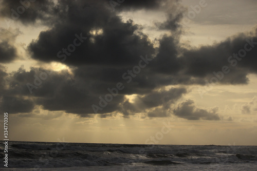 god rays rainy season ocean dark clouds