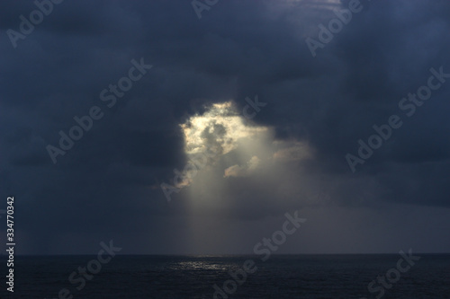 god rays rainy season ocean dark clouds