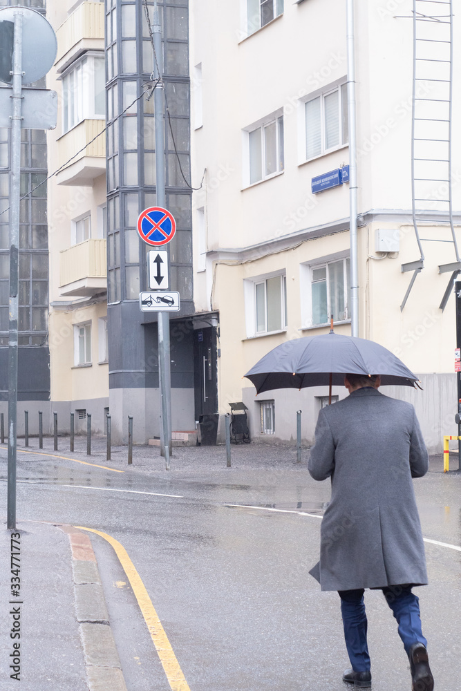 Fototapeta premium silhouette of a man with an umbrella walking in the rain