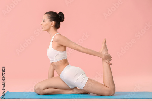 Fototapeta Naklejka Na Ścianę i Meble -  Young woman practicing yoga on color background