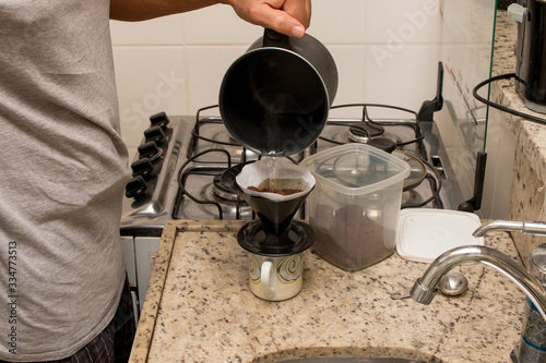 Man Brewing Coffee in his Kitchen with a One Cup Coffee Maker