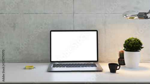 laptop on desk with plant  desk lamp  coffee cup and concrete wall 3D rendering