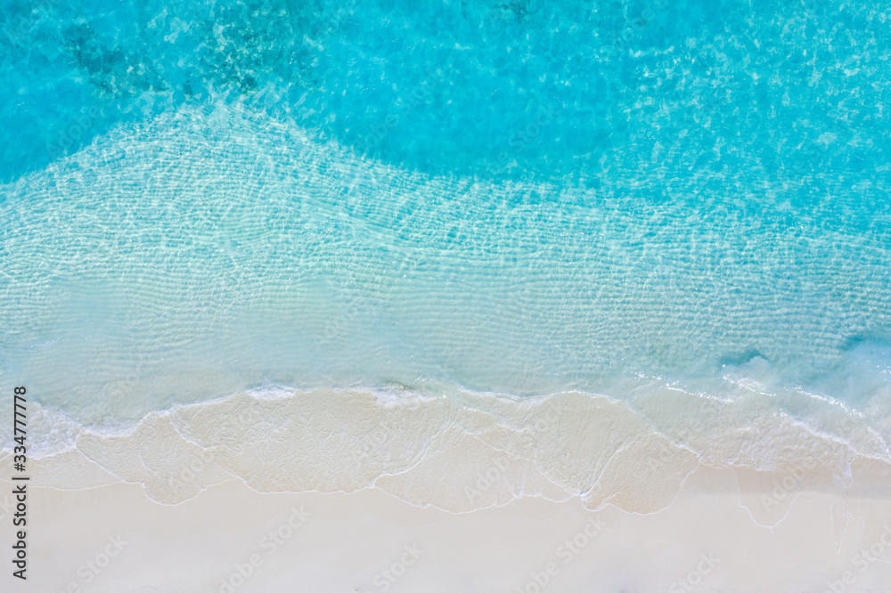 Tranquil tropical beach sea shore. Coast of exotic aerial sea and sand, view from above. Soft waves splashing, calm beach