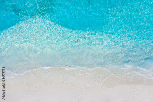 Tranquil tropical beach sea shore. Coast of exotic aerial sea and sand, view from above. Soft waves splashing, calm beach