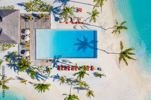 Aerial landscape, top view of beautiful tropical island beach and sea with umbrella and chair around swimming pool in hotel resort for travel and vacation. Luxurious aerial landscape