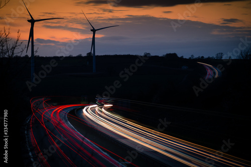 Wind turbines by main road with car light trails