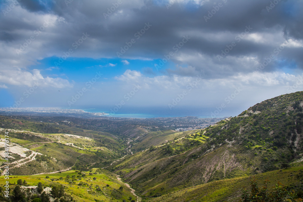 Panoramic view of beautiful green calming landscape of Mediterranean valley below clean blue cloudy sky.