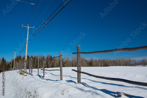 Vieille clôture en bois dans un champ en hiver canadien au Québec