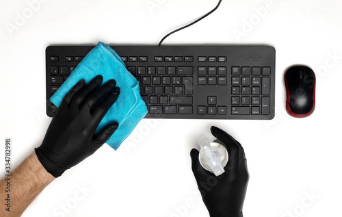 hands in protective gloves disinfect the keyboard
