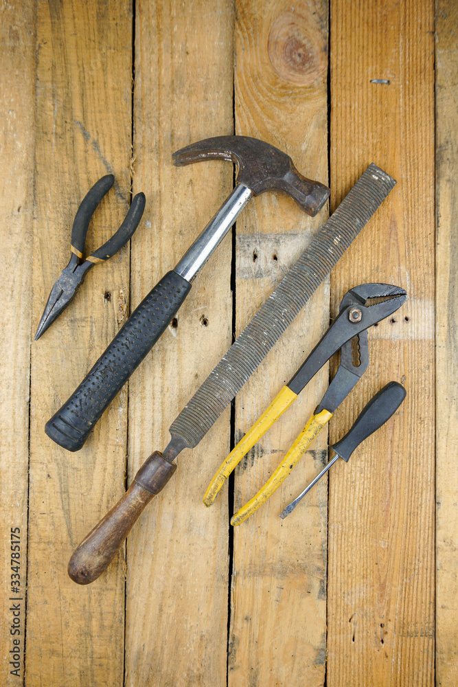 Assortment of hand tools spread out on rough wooden background. Assortment of hand tools spread out on rough wooden background.