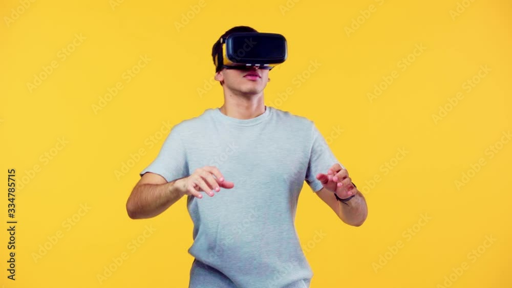 excited man using vr headset and gesturing isolated on yellow excited man using vr headset and gesturing isolated on yellow