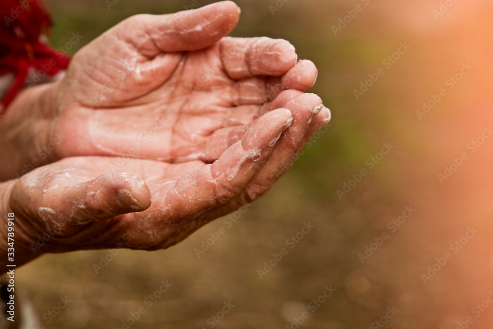 Old grandmother washes her hands with soap close-up. Soapy hands of an old woman. Hand disinfection due to an outbreak of coronavirus infection. U.S. coronavirus outbreak Old grandmother washes her hands with soap close-up. Soapy hands of an old woman. Hand disinfection due to an outbreak of coronavirus infection. U.S. coronavirus outbreak