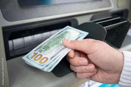 male hand hold money dollars received from an ATM