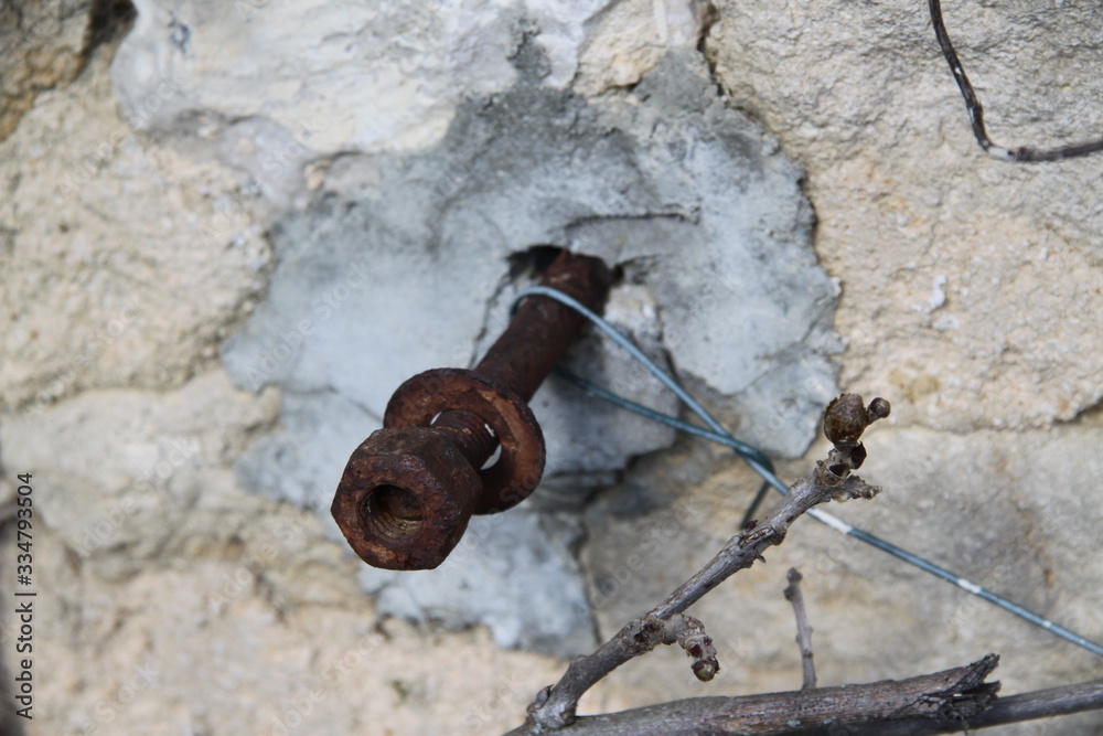 Sealed rusty iron nut bolt and screw in a wall