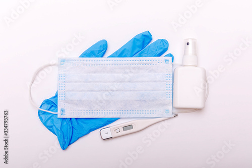 Coronavirus update in world. Protective glove and electronic thermometer on medical mask with flag on white background. Spread of corona virus in world. Covid 19 or ncov virus concept.