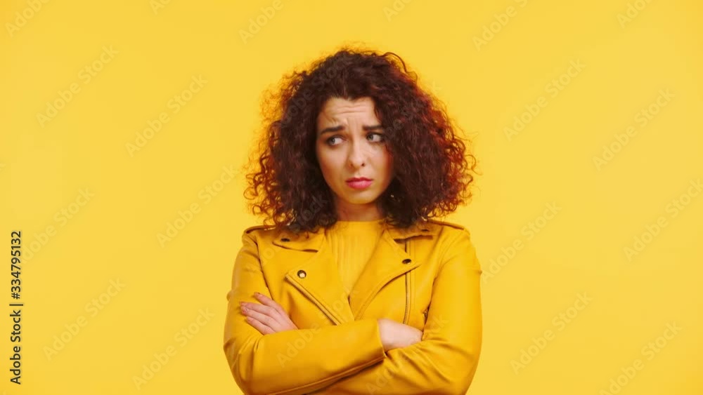 offended curly girl standing with crossed arms isolated on blue offended curly girl standing with crossed arms isolated on blue