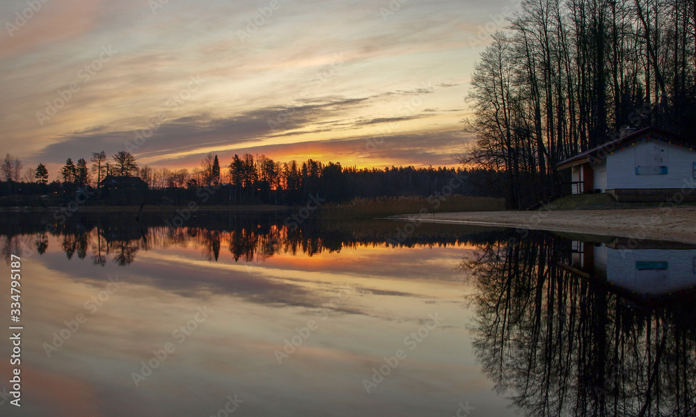 Obraz premium pink and purple pre dawn sunrise with mirrored reflections in lake