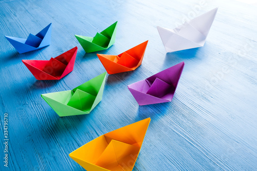 paper colored boats on a blue background