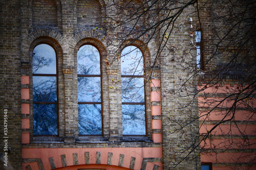 three arch circle windows in gray yellow brick wall three arch circle windows in gray yellow brick wall