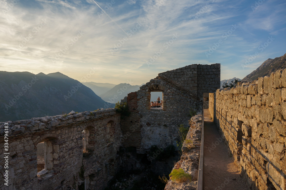 Ruined fortress of St. Ivan on top of the mountain in the last rays of the setting sun. Landscape scene. Kotor, Montenegro.