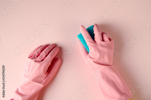 Pink cleaning gloves on coloful background