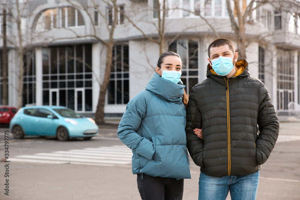 Couple wearing disposable masks outdoors. Dangerous virus