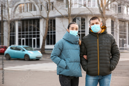 Couple wearing disposable masks outdoors. Dangerous virus © New Africa
