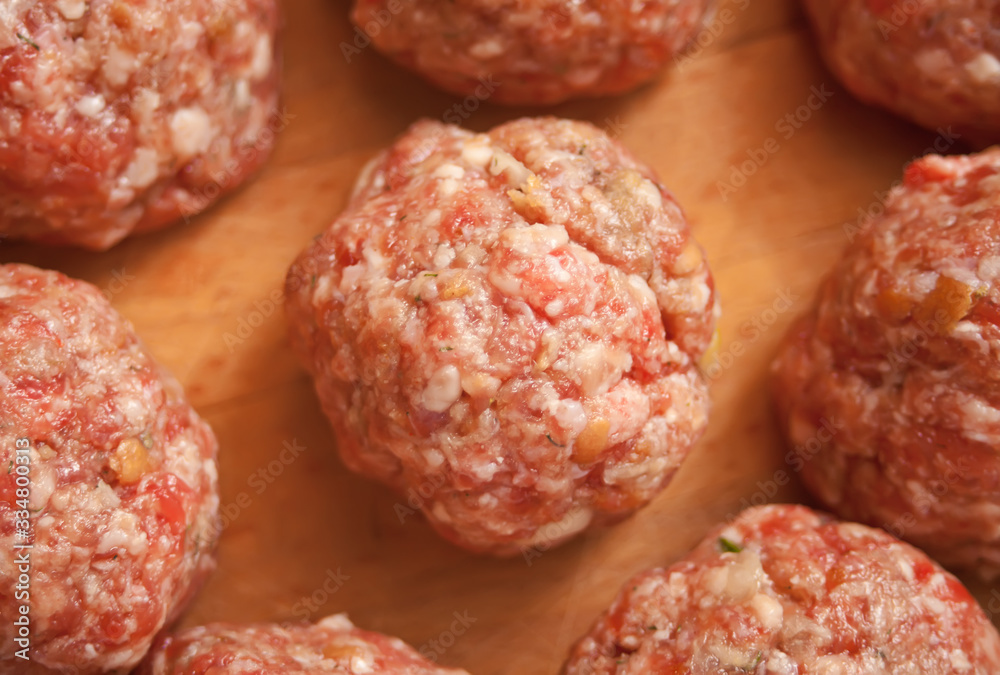 Raw meat balls on the wooden cutboard. Top view. Raw meat balls on the wooden cutboard. Top view.