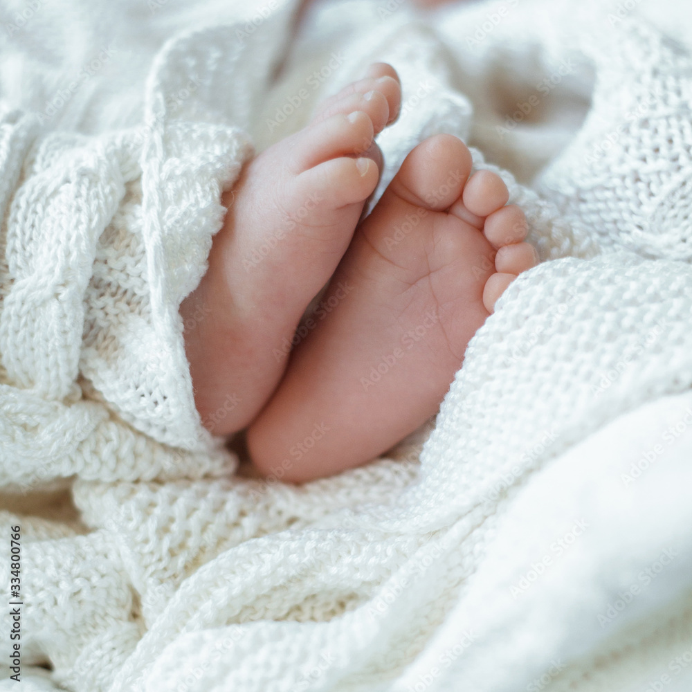 baby legs closeup wrapped in a white blanket blurred background baby legs closeup wrapped in a white blanket blurred background