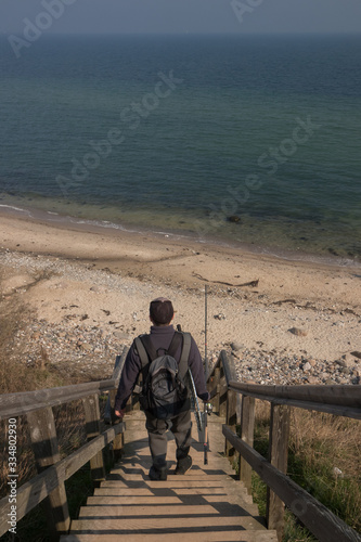 sea trout angler on the bordwalk steps to the Baltic Sea coast