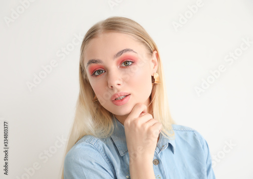 Beautiful fashionable woman on light background