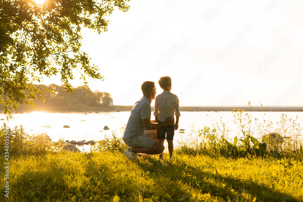 Father and his little son. Happy loving family walking outdoor in the light of sunset. Father and his little son. Happy loving family walking outdoor in the light of sunset.