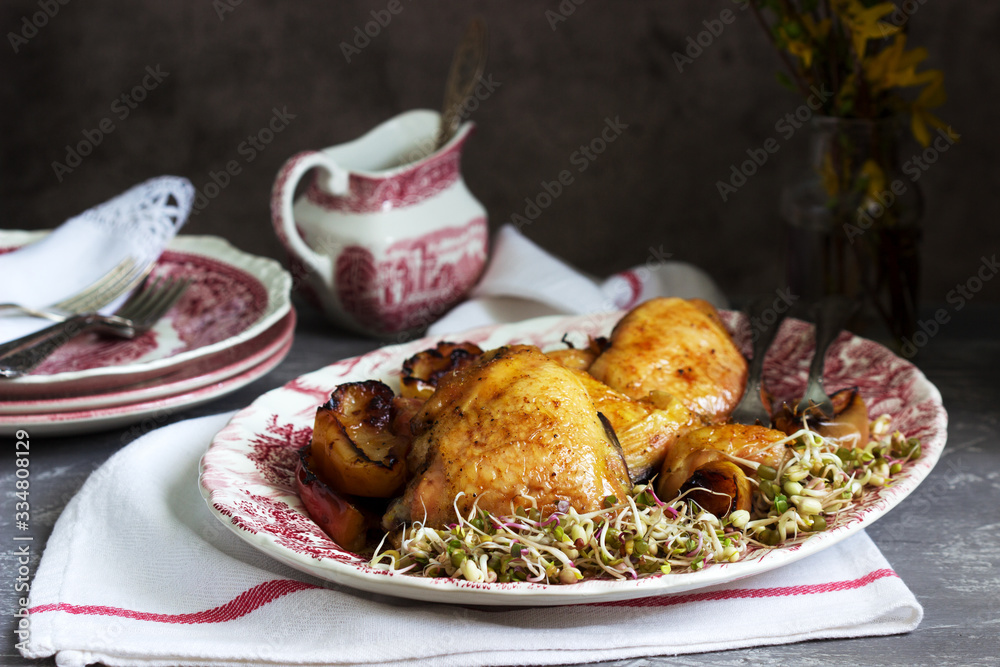 Baked chicken with apples, served with sprouted seeds and sauce.