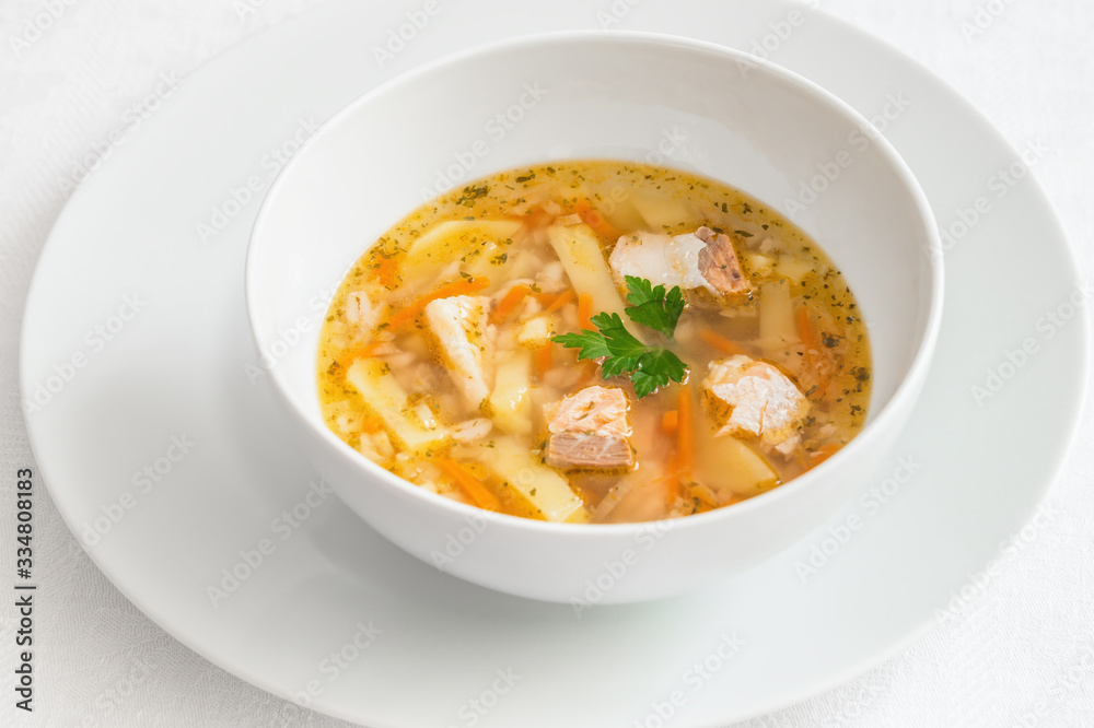 a bowl of salmon soup decorated with parsley leaves served on a plate a bowl of salmon soup decorated with parsley leaves served on a plate