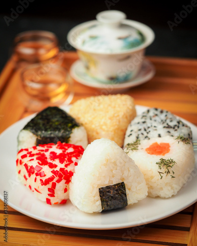 tea ceremony and different handmade onigiri close-up. traditional japanese food with kettle and mugs.