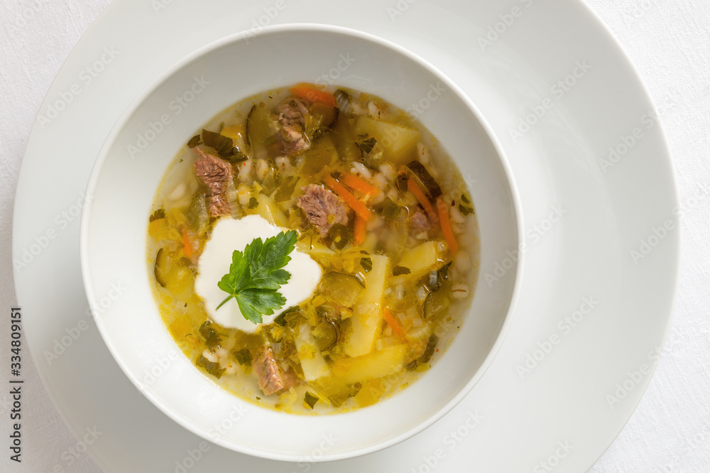 beef soup with pickled cucumber, potato, pearl barley, carrot, celery, onion, and herbs 
