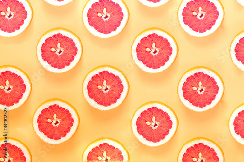 Fruit summer pattern with sliced grapefruit. Flat lay composition on yellow background. top view