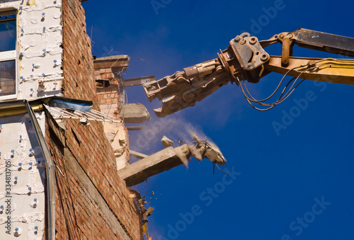 Fotografija A demolition of a building with a crane with a blue sky background