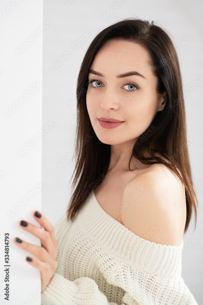 Portrait of attractive smiling young woman posing at home and looking at camera, image toned and noise added Portrait of attractive smiling young woman posing at home and looking at camera, image toned and noise added