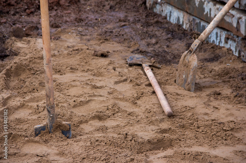 Bayonet shovel stuck in the ground at the construction site