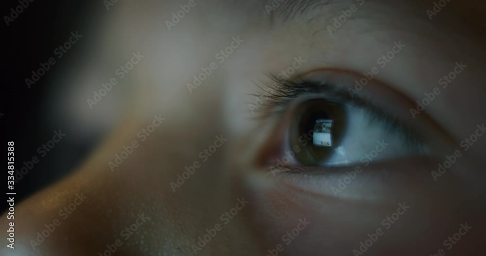 Macro  shot of child eyes while using a tablet, smartphone or computer. Concept: future of web technology, video technology, connections and vision of the future of children with the web. 