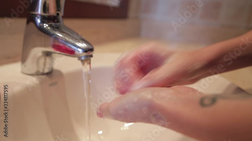 detail of a girl washing her hands in the bathroom.