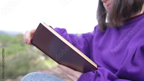 young girl reading a book outdoors on the terrace of the house