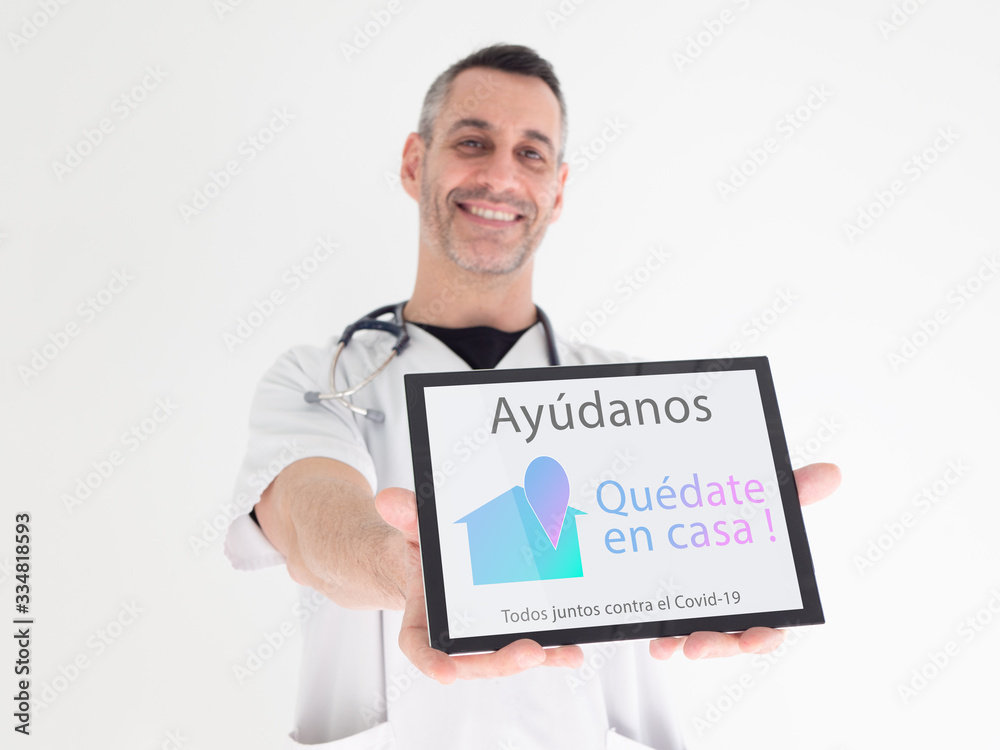Handsome middle aged male doctor hands an advice written in spanish on his tablet : Handsome middle aged male doctor hands an advice written in spanish on his tablet :